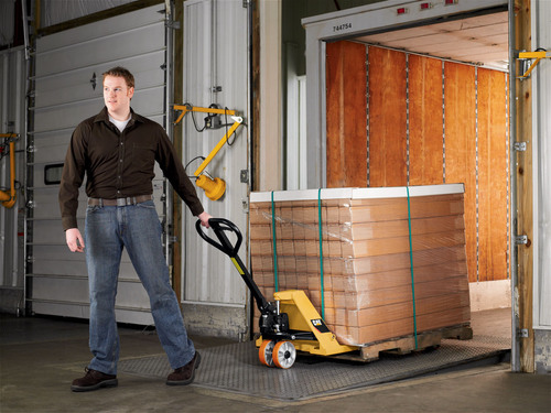 Man pulling Caterpillar pallet jack from elevator