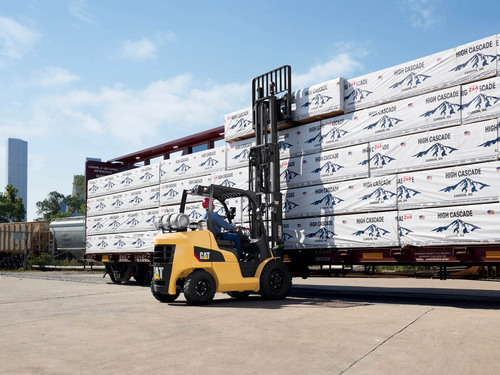 Man placing product on top of other product outside with 8,000 – 12,000 lb. CAT forklift