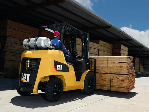 Man transporting wood with 8,000 – 12,000 lb. CAT forklift