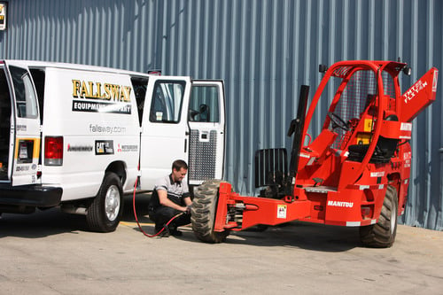 Fallsway employee putting air into Manitou forklift tires